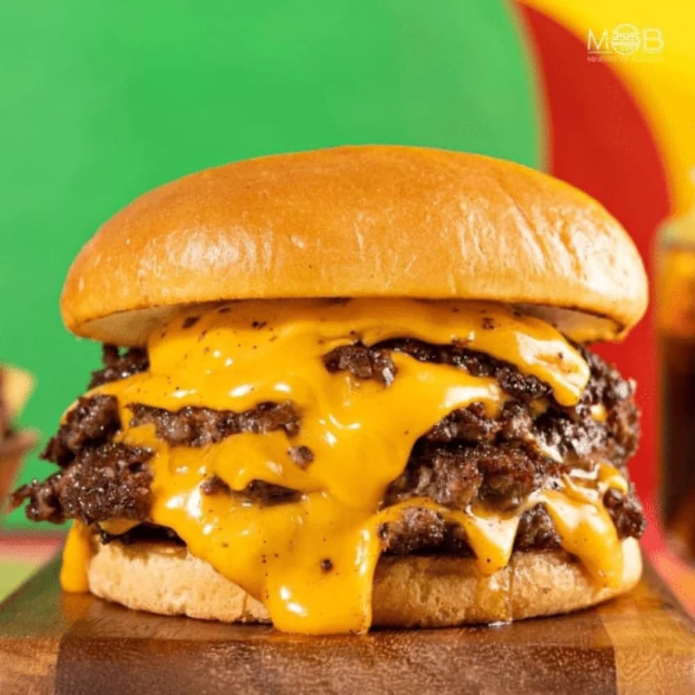 Drie Angus patties, drie plakken American cheese en alle toppings. De ultieme burger — hou twee handen vrij.