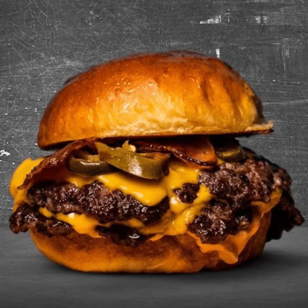 Drie Angus patties, drie keer cheese en alle toppings op brioche. De absolute beast — sorry voor je handen.